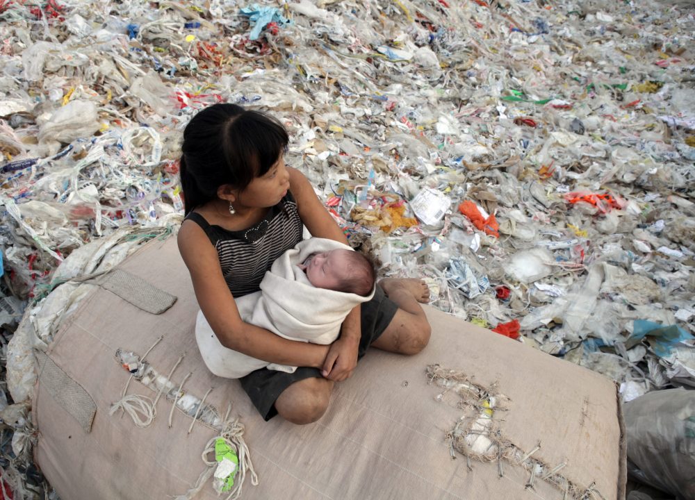 Plastic China documentary – girl sitting on a pile of recycling